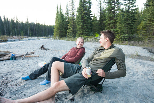 Happy couple relaxing in camp chairs outdoors
