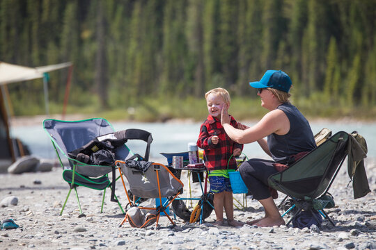 Mother applies sunscreen to her son while camping