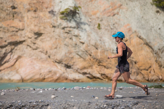 Fit woman running on a scenic trail by a river