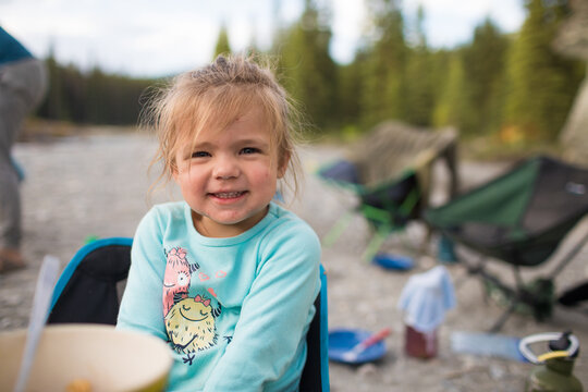 Cute toddler girl smiles for the camera outdoors