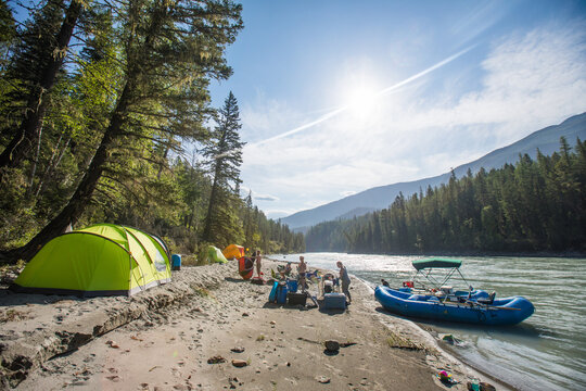 Friends camping and rafting on a sunny riverbank