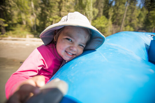 Happy little girl with a dirty face on a raft