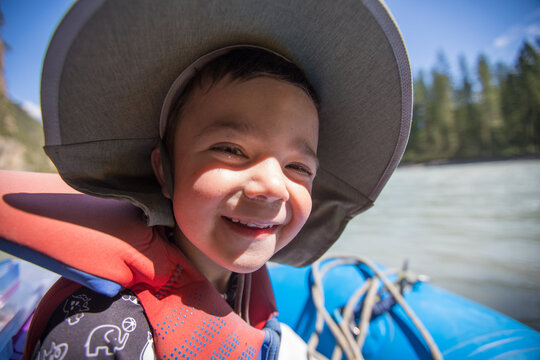 Happy little boy smiling on a river raft