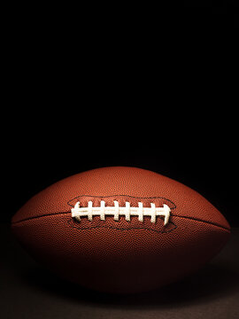 American football centered against a black background