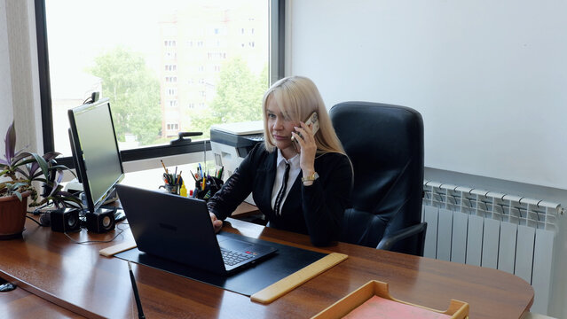 Efficient businesswoman multi tasking in office, managing business responsibilities