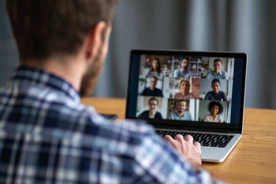 Man working on laptop during a virtual video conference meeting for remote work