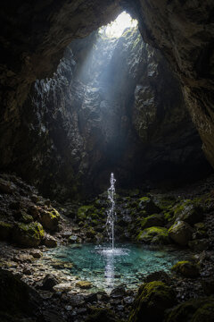 Hidden spring rising inside a cave beneath daylight