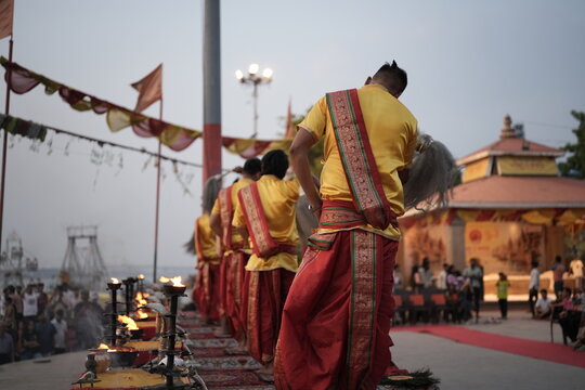 Morning Ganga aarti rituals performed by unrecognized Hindu priests at Assi Ghat in Varanasi with selective focus. Fire in the brass made utensils for Aarti in Banaras.