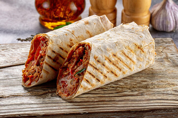 Grilled meat wraps with vegetables on wooden board