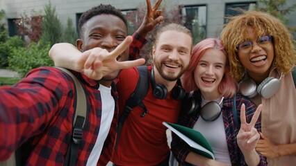 Fototapeta premium Web cam view four multiracial university students happy smiling cuddle posing looking at camera in city group of diversity friends diversity buddies smile cuddling together outdoors for selfie photo