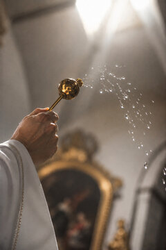 Priest sprinkling holy water inside a church service