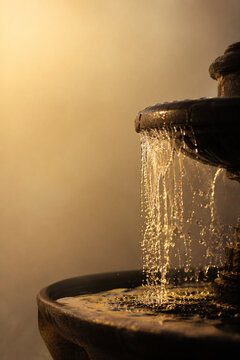 Water flowing from stone fountain in warm evening light