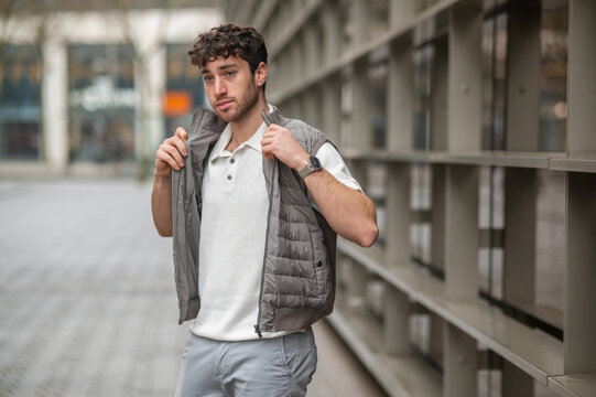 Young man adjusting gilet urban autumn fashion