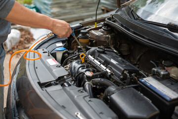 Fototapeta premium A person cleans a car engine with a pneumatic tool. Photo on the topic of repair and maintenance of the engine of a modern car. High quality photo