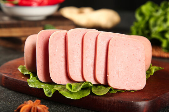 Sliced Pork Luncheon Meat on Wooden Board with Fresh Vegetables