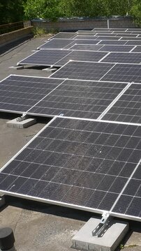 The Concept of Green Energy in an Urban Environment. Solar panels on the roofs of old apartment buildings. A rooftop solar power plant - Vetical video