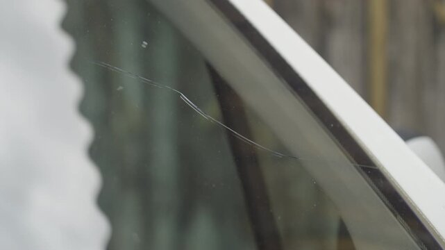 Fractured car windscreen from the edge on the drivers side close-up 4K
