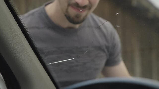 Male person check the fractured windscreen on the car view from inside 4K