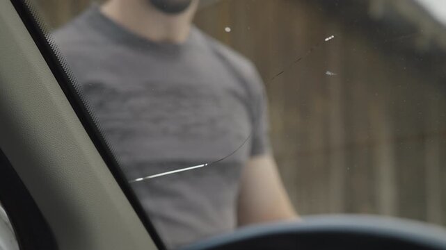 Male person check the fractured windscreen on the car view from inside 4K