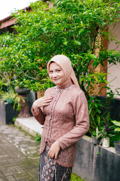 Asian Hijab Woman in Traditional Javanese Kebaya Lace Dress, posing outdoor