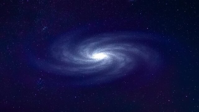 Spiral galaxy rotates slowly and drifts through deep space against dense star field. Smooth motion video of galaxy with luminous core, and diffuse arms. Futuristic space travel concept footage
