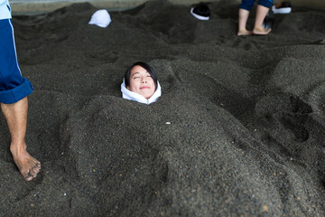 Fototapeta premium Woman relaxing in hot sand bath&nbsp;