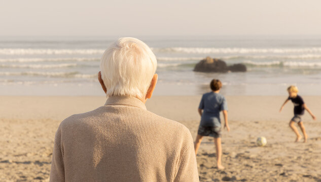 rear view of elderly man looking out at ocean waves, grotto beach, hermanus, South Africa