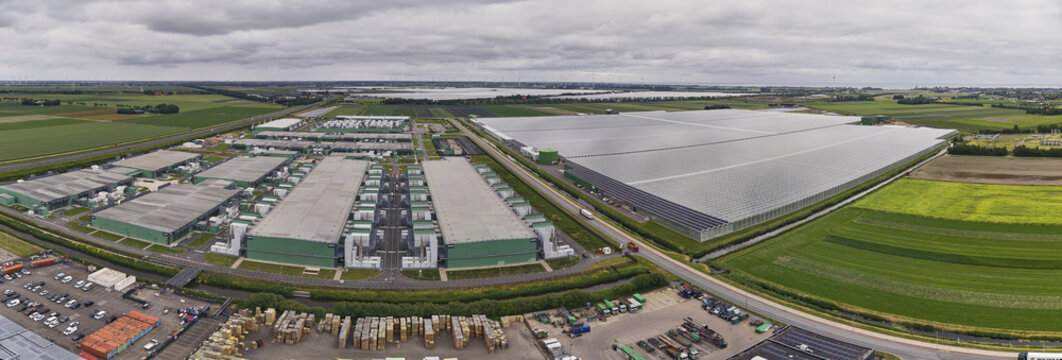 Middenmeer, Netherlands - 15 June 2026: Aerial view of Microsoft Datacenter Western Europe AMS Campus featuring large industrial buildings, backup power plants, and greenhouses.