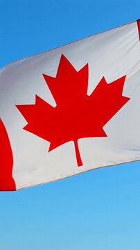 Canadian flag waving proudly against a clear blue sky