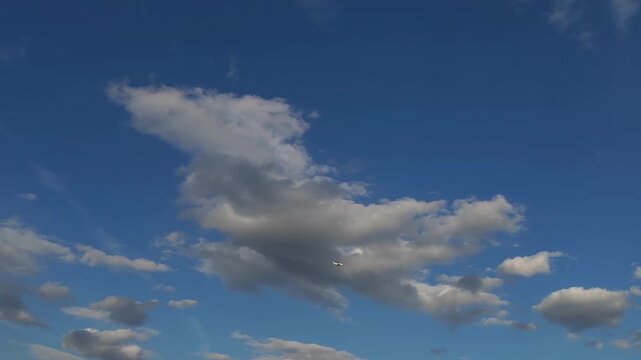 雲の広がる青空を飛行する飛行機の爽やかな構図