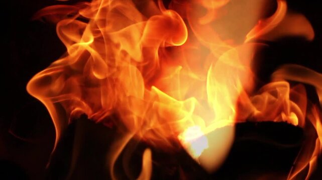 Fire flames with flying sparks close up. Abstract texture of blazing fire, dynamic burning tongues of flame with bright bokeh, heat, danger, energy and disaster concept