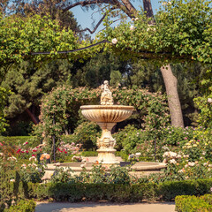 Obraz premium Beautiful garden with an ancient stone fountain in the huge Retiro Park in Madrid, Spain.