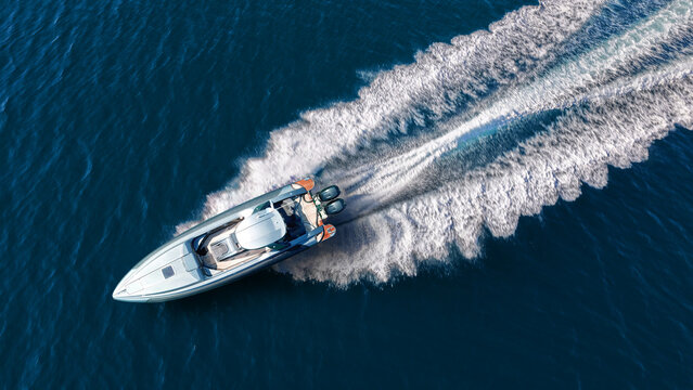 Aerial drone ultra wide top down photo with copy space of luxury rigid inflatable speed boat cruising in high speed in Aegean deep blue sea, Greece	