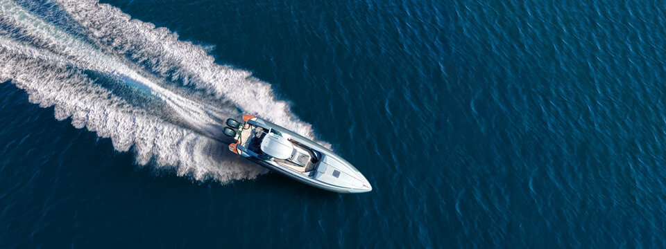 Aerial drone ultra wide top down photo with copy space of luxury rigid inflatable speed boat cruising in high speed in Aegean deep blue sea, Greece	