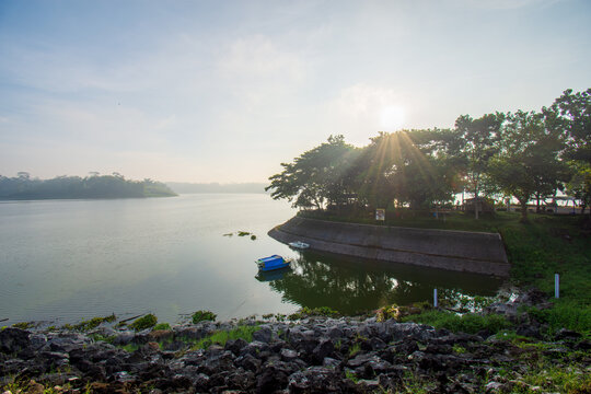 Steep stone staircase structure next to concrete spillway at Sutami dam reservoir surrounded by lush green forest, civil engineering infrastructure in East Java