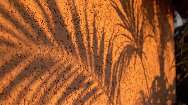 Wall Plaster with Orange and Gray Texture, Featuring Sunburst-Like Shadows That Create a Warm, Dramatic Lighting Pattern on the Surface
