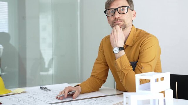 Professional architect designing a new building project, planning with blueprints and a scale model in a modern office, developing urban structures and innovative construction ideas