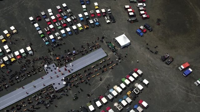 4K aerial view of many 4x4 jeeps gathered for an outdoor event at Mount Bromo sand sea.