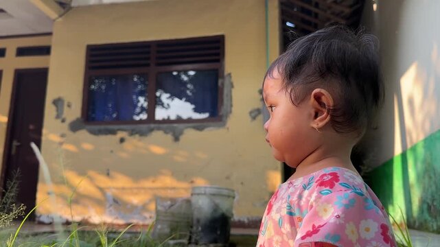 Asian Toddler Girl Looking Around and Clapping Outdoors at Sunset