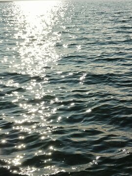 Sparkling sun reflections on blue sea water surface