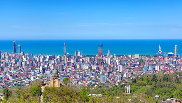 Panoramic skyline of Batumi, Georgia, viewed from Argo Cable Car hill. Modern skyscrapers, Black Sea coastline, urban architecture and cityscape under a clear blue sky.