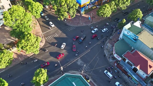Buon Ma Thuot, Dak Lak, Vietnam - May 7, 2026: A dynamic high-angle urban timelapse capturing a bustling intersection during evening rush hour in Vietnam. Hundreds of motorcycle