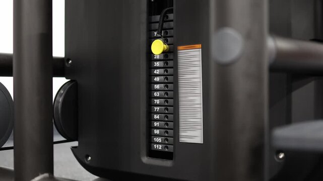 Athlete gradually increases weight on a gym machine moving from light resistance to heavier loads showing strength progression workout intensity and fitness improvement