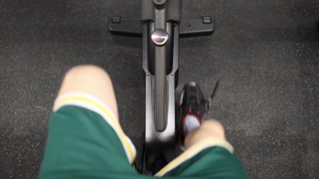 Top down view of person pedaling exercise bike during indoor cycling workout focused on endurance improvement cardiovascular fitness and active lifestyle