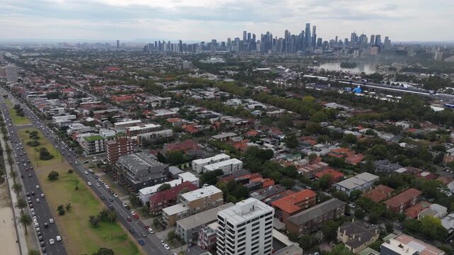 MELBOURNE, AUSTRALIA - MARCH 2026: Aerial drone shot moving up and forward over St Kilda revealing the city skyline and Albert Park lake during F1 qualifying day.