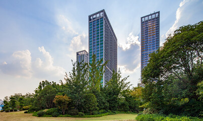 Modern High-Rise Apartments Above Green Park with Blue Sky © LyVan