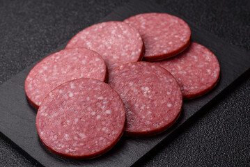 Naklejka premium Slices of smoked salami or pepperoni for making sandwiches or pizza at home. Sausage slices