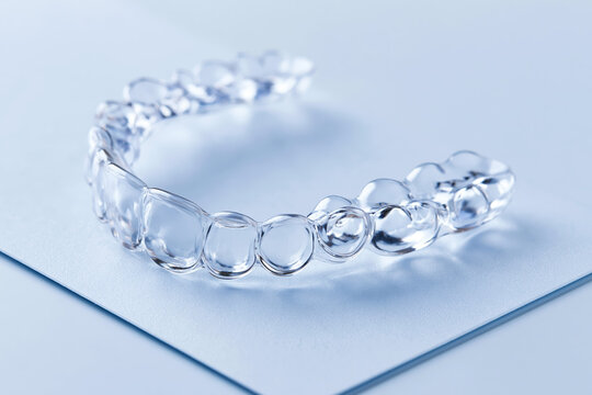Clear aligners next to a blank treatment plan card on a light background for orthodontic treatment, oral care options and planning for patients