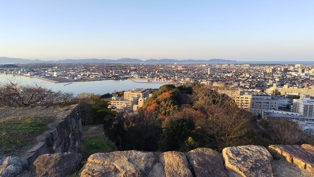 米子城跡の天守台石垣から夕暮れ時に一望する中海と米子市街地のワイドパノラマ絶景

