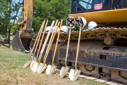Groundbreaking Ceremony Preparations with Excavator and Shovels at Construction Site